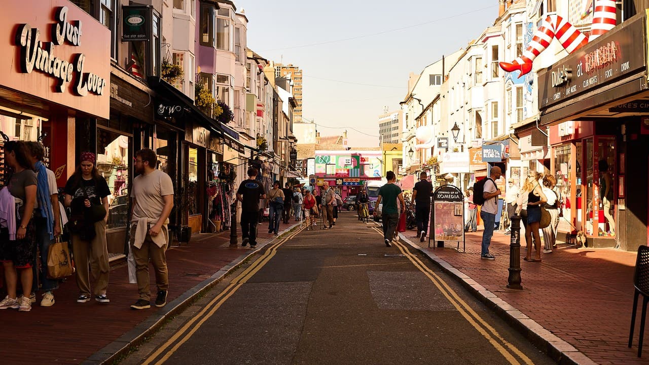 People walking along a sunlit independent shopping street in Brighton's North Laine